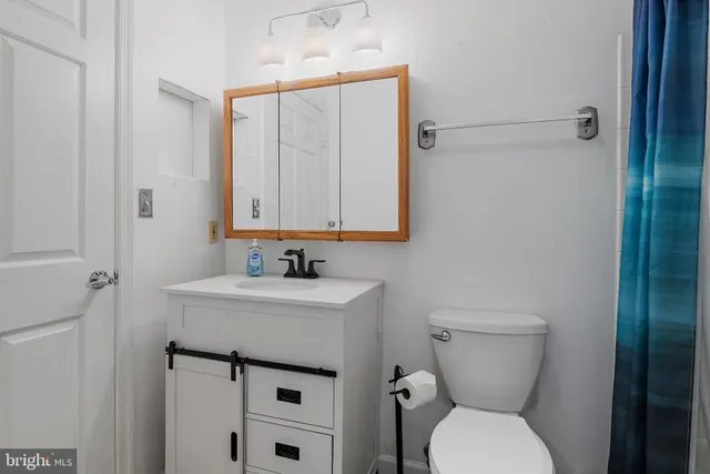 a bathroom with a toilet sink and mirror