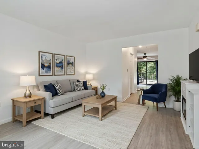a living room with furniture and a painting on the wall