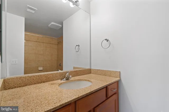 a bathroom with a granite countertop sink and a mirror