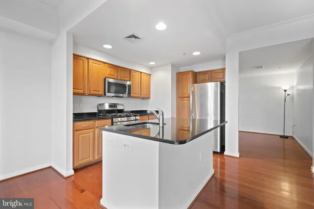 a kitchen with stainless steel appliances granite countertop a refrigerator a stove top oven a sink and dishwasher