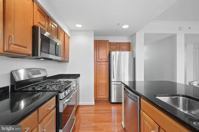 a kitchen with stainless steel appliances granite countertop a sink stove and refrigerator