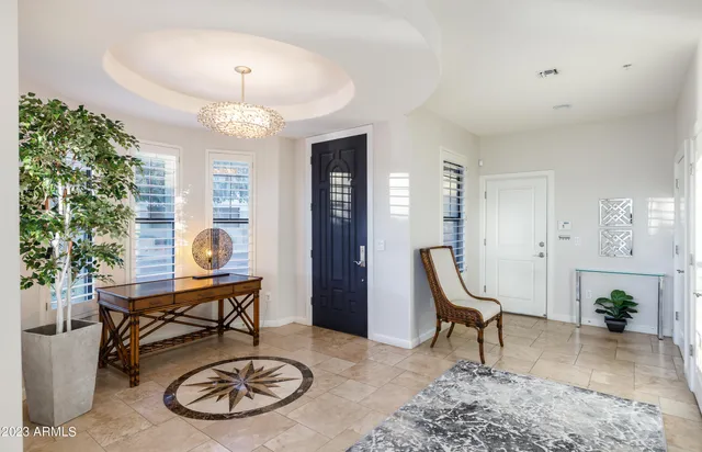 a living room with furniture a dining table and a chandelier