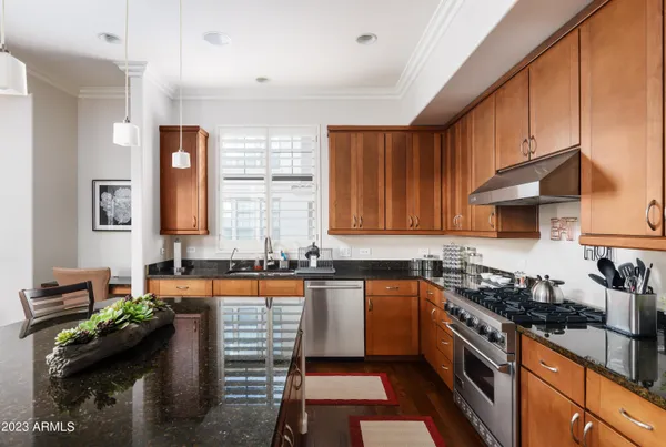a kitchen with granite countertop a sink stove and cabinets