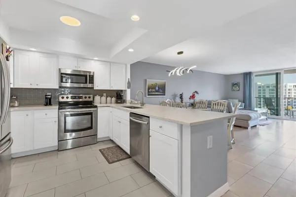 a kitchen with granite countertop a refrigerator and a stove top oven