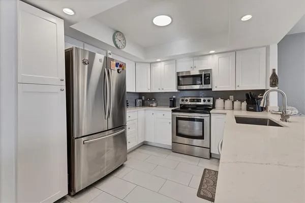 a kitchen with stainless steel appliances granite countertop a refrigerator and a stove top oven