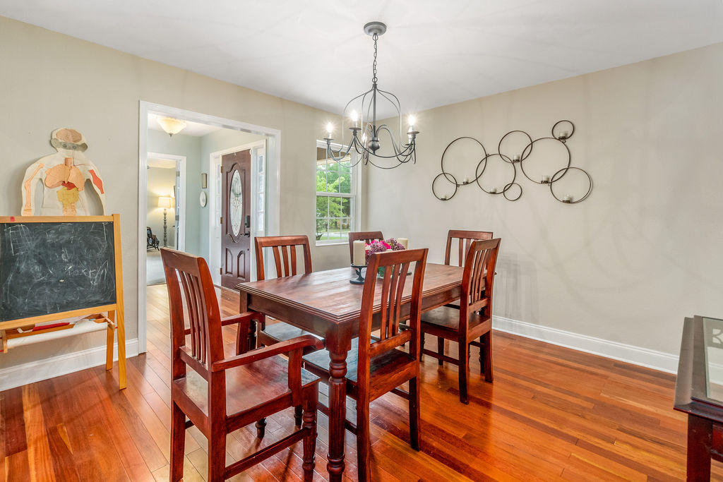 2135 Semur Road Pensacola, FL 32503 - Photo 17 of 37 a dining room with furniture a chandelier and wooden floor