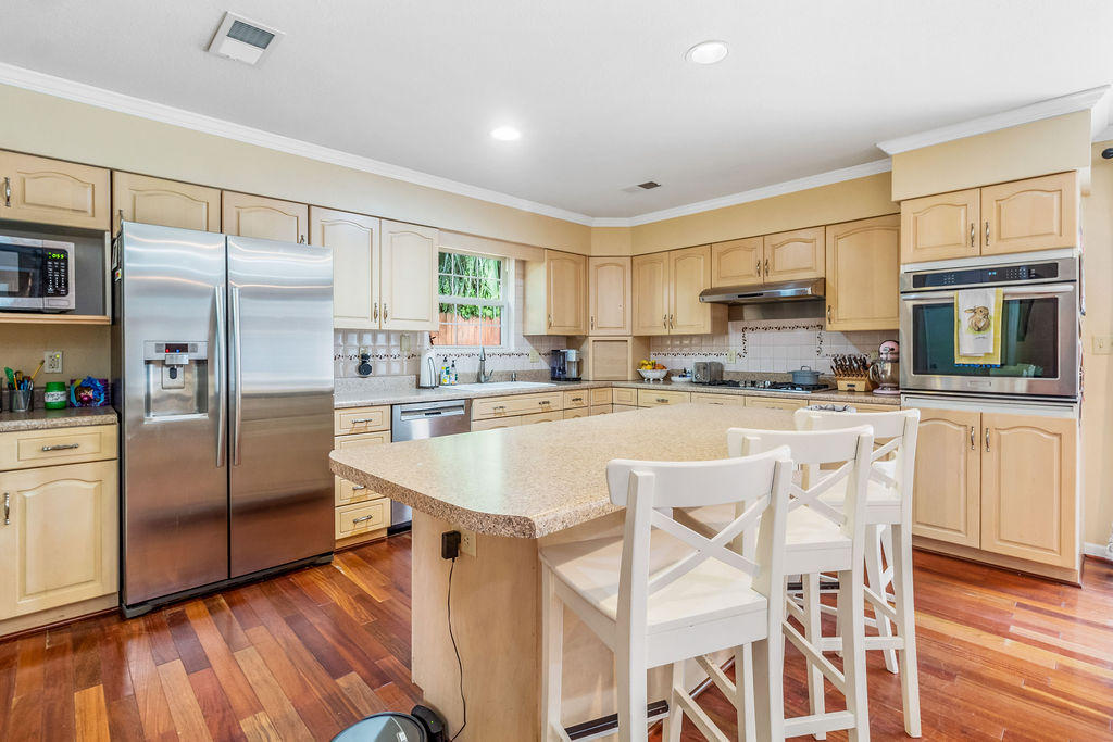 2135 Semur Road Pensacola, FL 32503 - Photo 10 of 37 a kitchen with stainless steel appliances granite countertop a refrigerator a stove and white cabinets with wooden floors