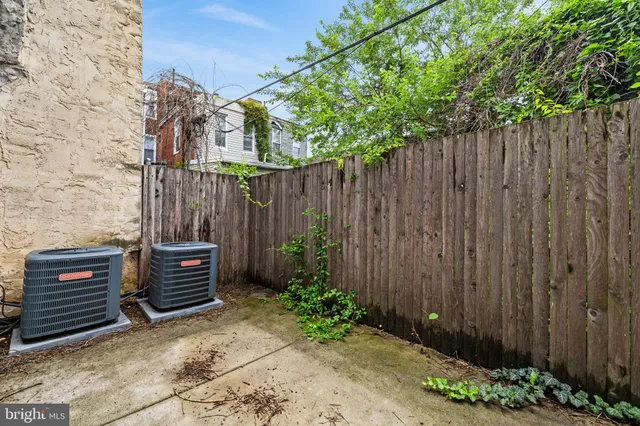 a backyard of a house with potted plants and wooden fence