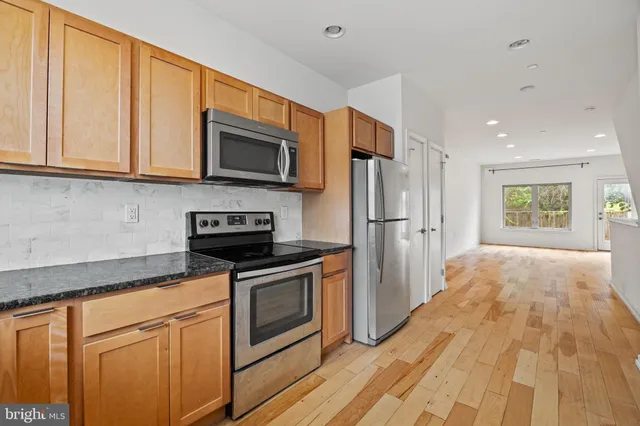 a kitchen with stainless steel appliances granite countertop a refrigerator stove and microwave