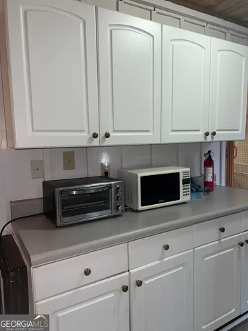 a kitchen with white cabinets and white appliances