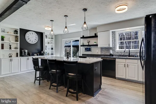 a kitchen with granite countertop a sink cabinets and wooden floor