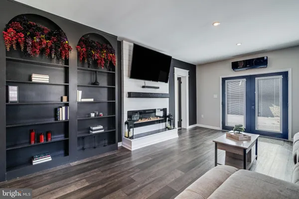 a living room with furniture a flat screen tv and a floor to ceiling window