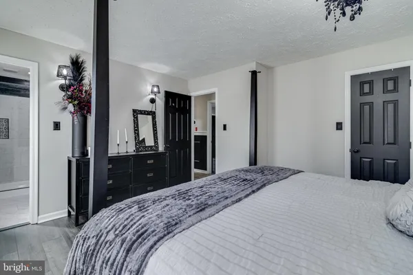 a bedroom with a bed and a large mirror on dresser