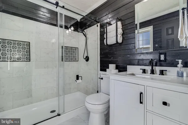 a bathroom with a sink a toilet and shower