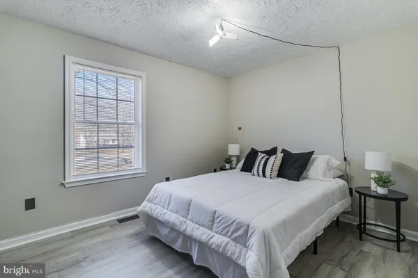 a large bed sitting in a bedroom next to a window and a chair