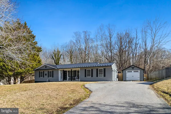 a front view of house with yard and trees