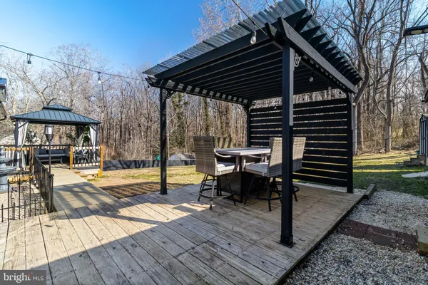 a view of a patio with table and chairs with wooden floor and fence
