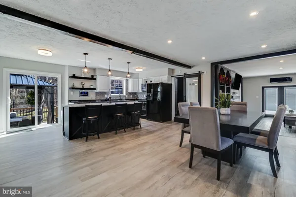 a living room with stainless steel appliances kitchen island granite countertop furniture wooden floor and a kitchen view