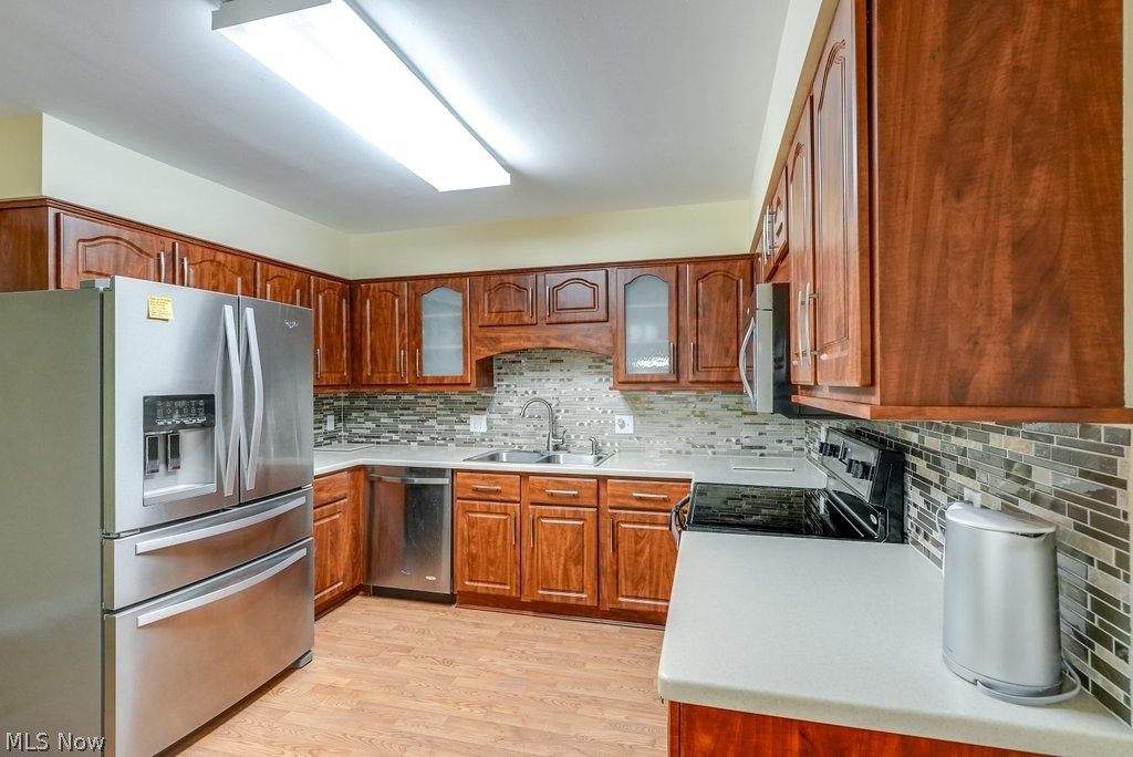 888 Hampton Ridge Drive Akron, OH 44313 - Photo 4 of 24 Kitchen with light hardwood / wood-style floors, stainless steel appliances, tasteful backsplash, and sink