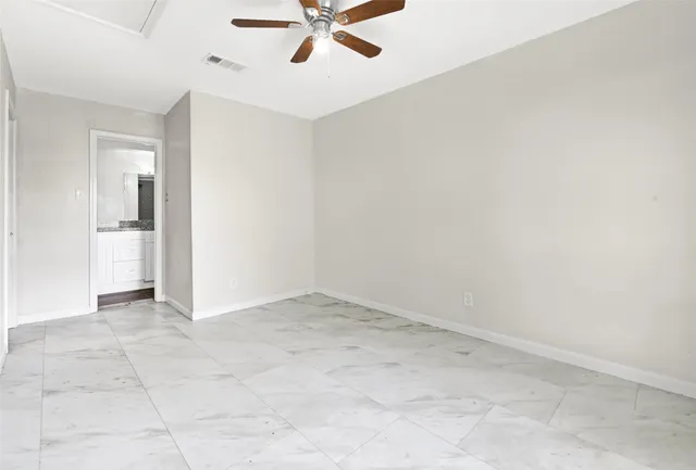 an empty room with a ceiling fan and carpet