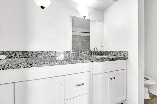 a bathroom with a granite countertop sink and a mirror