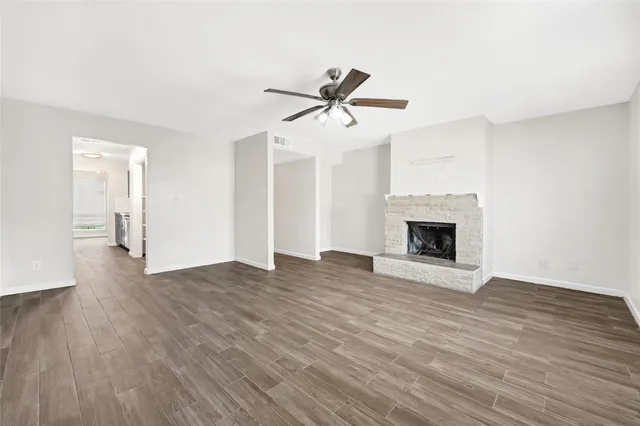 a view of empty room with wooden floor and fireplace