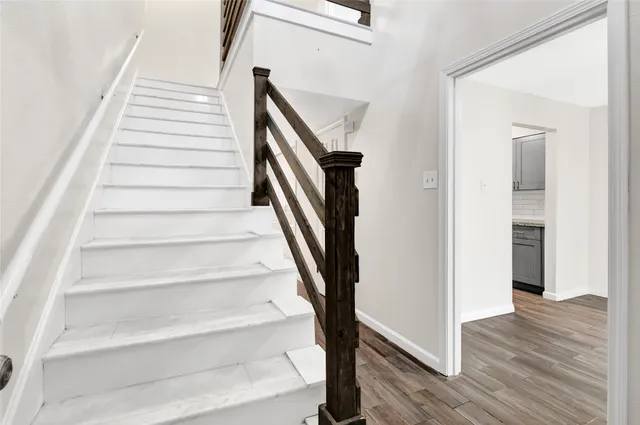 a view of staircase with white walls and railing