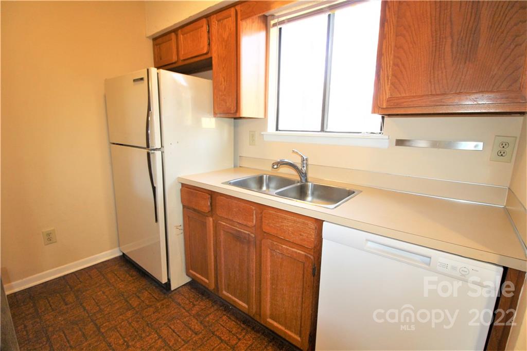 11072 Cedar View Road Charlotte, NC 28226 - Photo 8 of 18 a kitchen with a sink a refrigerator and cabinets