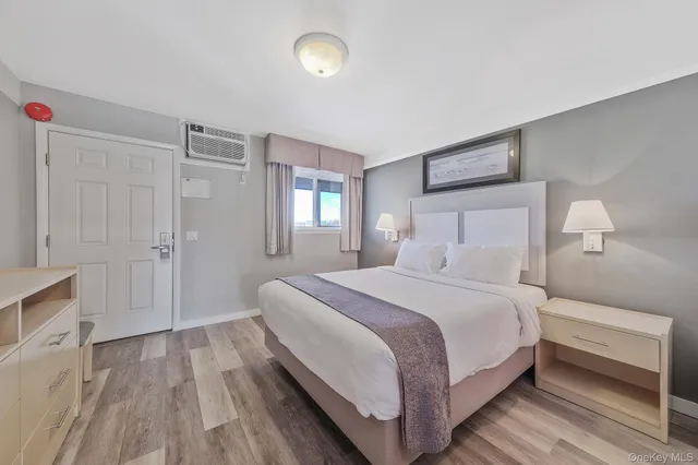 a bedroom with a bed and closet with wooden floor