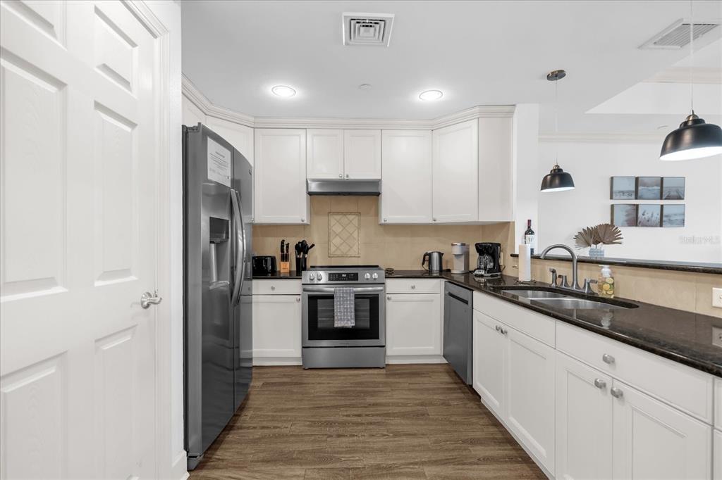 1362 Centre Ct Ridge Drive, Unit 102 Reunion, FL 34747 - Photo 8 of 35 a kitchen with stainless steel appliances granite countertop a stove a sink and a refrigerator