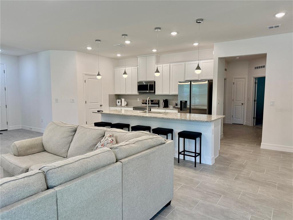15467 Maynard Avenue Port Charlotte, FL 33953 - Photo 3 of 13 a living room with stainless steel appliances kitchen island furniture and a view of kitchen
