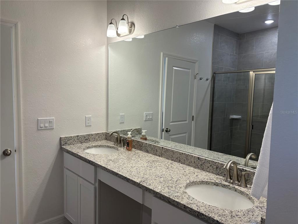 15467 Maynard Avenue Port Charlotte, FL 33953 - Photo 9 of 13 a bathroom with a granite countertop sink and a mirror