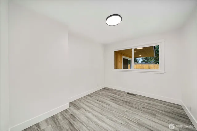 a view of a room with wooden floor and white walls