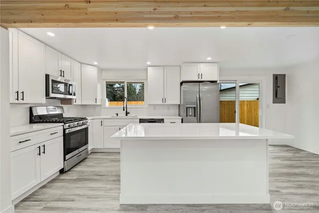 a kitchen with stainless steel appliances a white stove top oven cabinets and a refrigerator