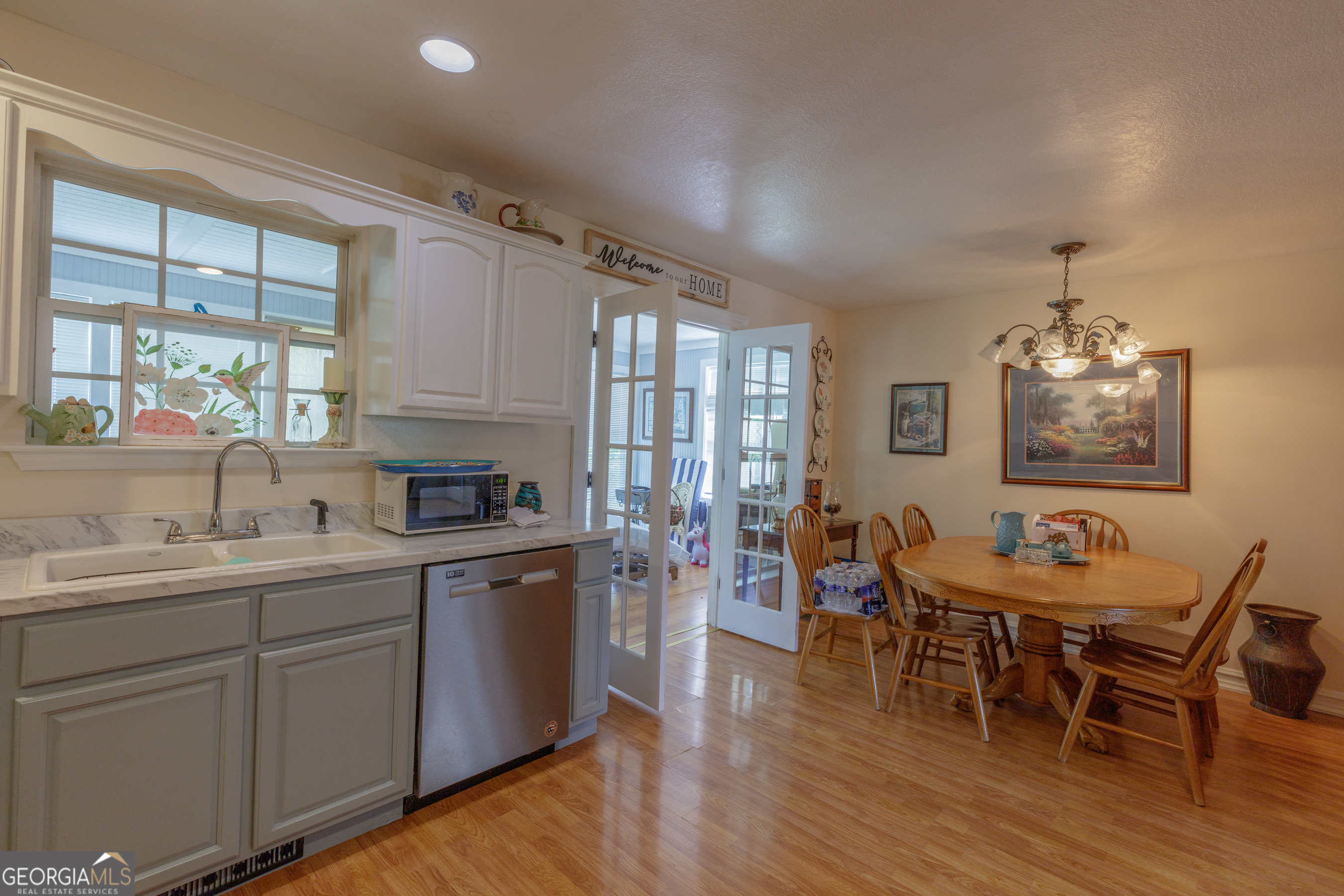 765 Greenbush Road LaFayette, GA 30728 - Photo 48 of 68 a kitchen with stainless steel appliances granite countertop a stove a sink dishwasher a dining table and chairs with wooden floor