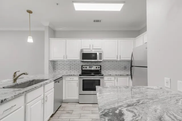 a kitchen with stainless steel appliances granite countertop a stove and a sink