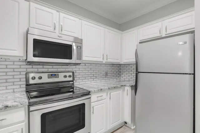 a kitchen with cabinets stainless steel appliances and a counter space