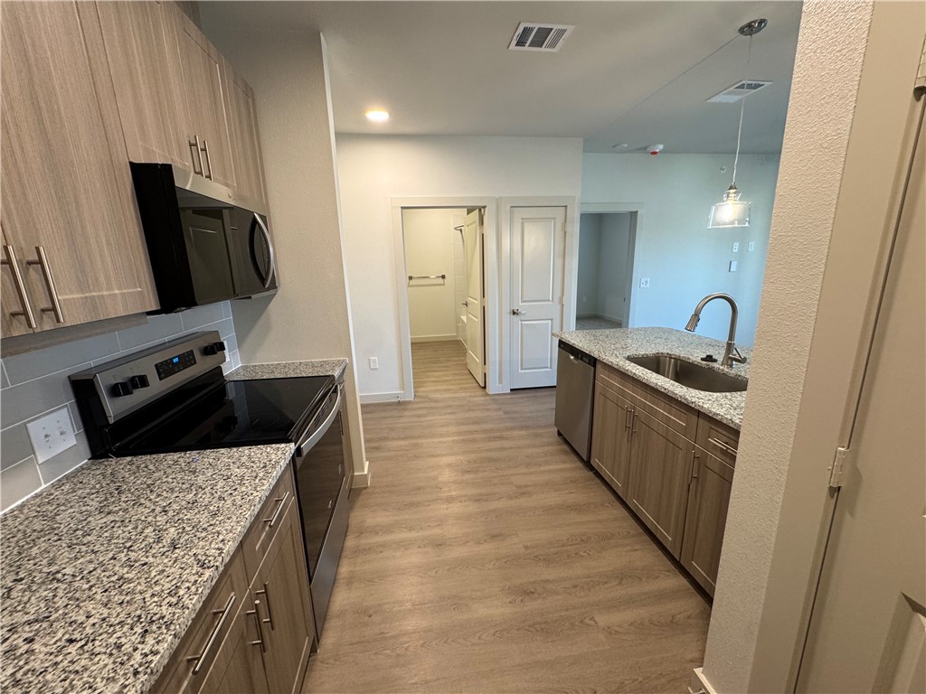 6000 Jones Road, Unit 4211 Bryan, TX 77807 - Photo 9 of 19 a kitchen with stainless steel appliances granite countertop a sink stove and refrigerator