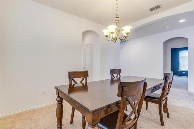 a view of a dining room with a table and chairs