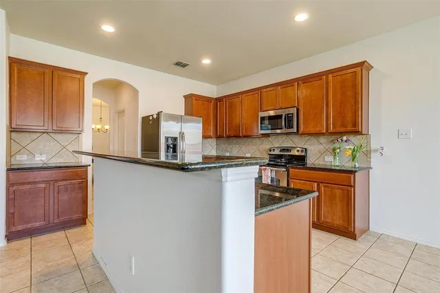 a kitchen with granite countertop wooden cabinets a stove top oven and granite counter top