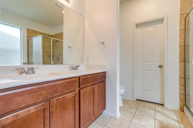 a spacious bathroom with a double vanity sink a mirror and a bathtub