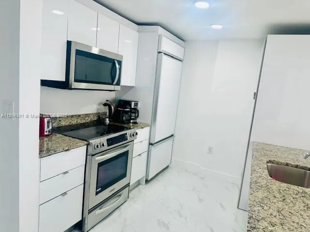 a kitchen with a sink stove and microwave