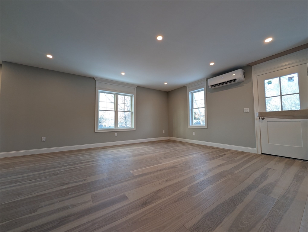 46 Holt Road, Unit B Bourne, MA 02532 - Photo 11 of 22 an empty room with wooden floor and windows