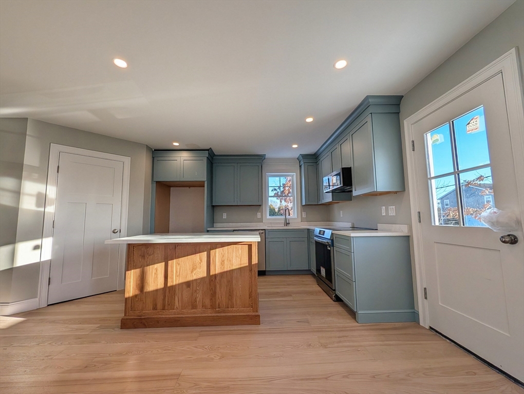 46 Holt Road, Unit B Bourne, MA 02532 - Photo 7 of 22 a large kitchen with stainless steel appliances granite countertop a large window a oven and a refrigerator