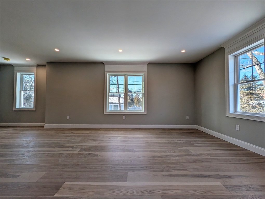 46 Holt Road, Unit B Bourne, MA 02532 - Photo 10 of 22 an empty room with wooden floor and windows