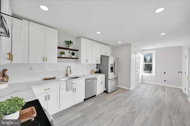 a kitchen with white cabinets and stainless steel appliances