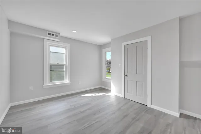 a view of an empty room with wooden floor