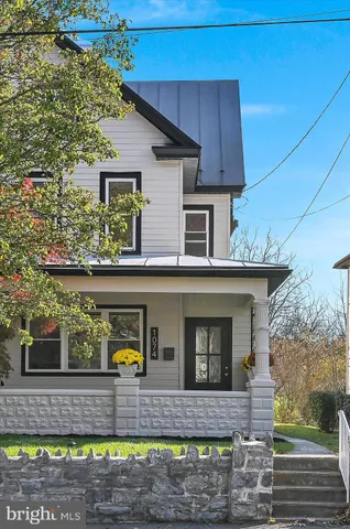 a front view of a house with a garden and trees