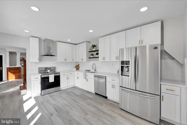 a kitchen with white cabinets and stainless steel appliances