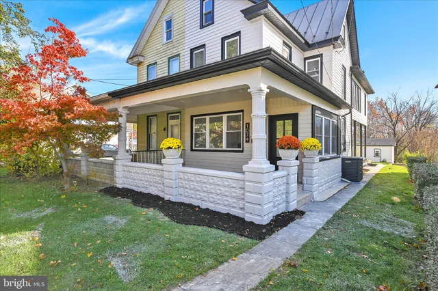 a front view of a house with a garden and trees